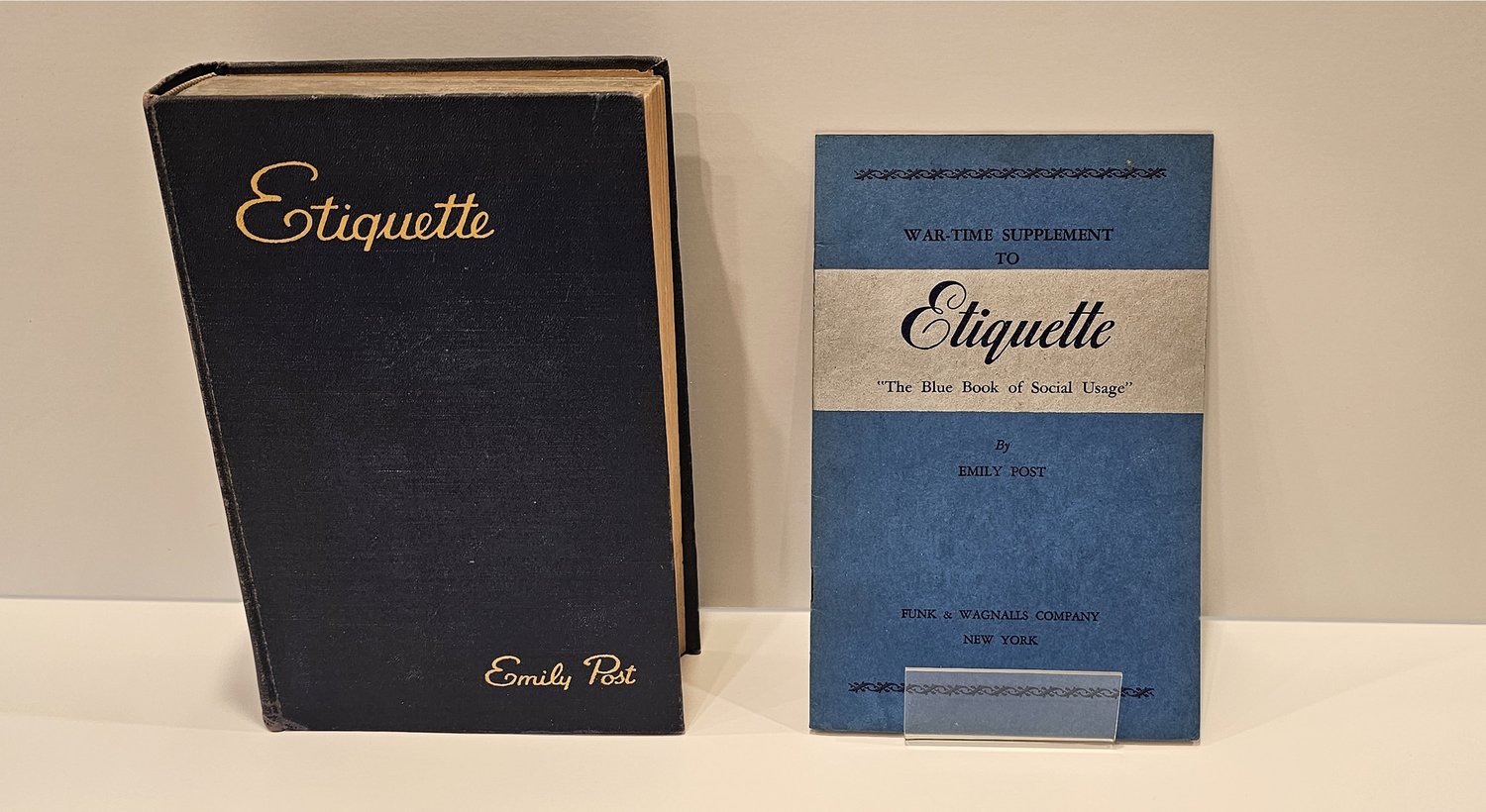 Emily Post's Etiquette beside a slim blue War-Time Supplement booklet.